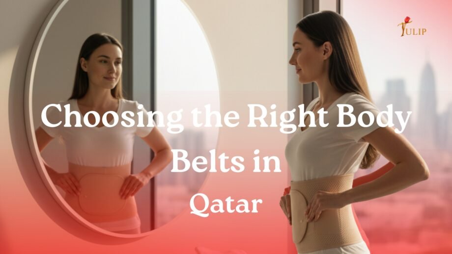 A woman wearing a beige body support belt while looking at herself in a mirror, standing in a bright modern room with a soft city skyline in the background. The scene reflects comfort, posture support, and confidence.